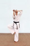 A menina em um quimono do branco joga esportes imagens de stock A menina em um quimono do branco joga esportes imagens de stock