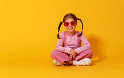 Menina engra?ada engra?ada da crian?a na roupa cor-de-rosa no fundo amarelo imagem de stock royalty free Menina engra?ada engra?ada da crian?a na roupa cor-de-rosa no fundo amarelo imagem de stock royalty free