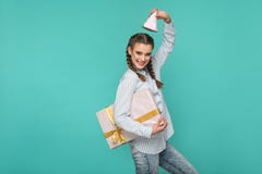 Menina engraçada em camisa azul listrada que está com caixa de presente pontilhada a fotografia de stock royalty free Menina engraçada em camisa azul listrada que está com caixa de presente pontilhada a fotografia de stock royalty free
