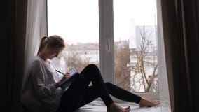 A menina escreve suas memórias em um caderno vídeos de arquivo A menina escreve suas memórias em um caderno vídeos de arquivo