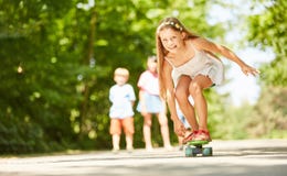 A menina está tendo o divertimento ao skateboarding imagens de stock royalty free A menina está tendo o divertimento ao skateboarding imagens de stock royalty free