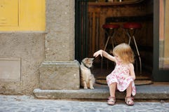 Menina feliz adorável e um gato imagens de stock Menina feliz adorável e um gato imagens de stock