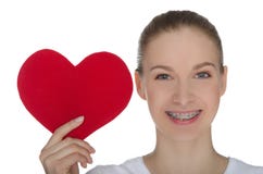 Menina feliz com as cintas nos dentes e no coração vermelho fotografia de stock Menina feliz com as cintas nos dentes e no coração vermelho fotografia de stock