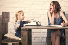 Menina feliz e criança que sentam-se na tabela foto de stock Menina feliz e criança que sentam-se na tabela foto de stock