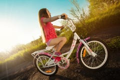 Menina feliz que monta uma bicicleta foto de stock royalty free Menina feliz que monta uma bicicleta foto de stock royalty free