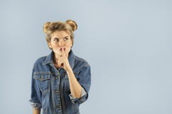 A menina fortemente emocional bonita nova mostra gestos diferentes em um fundo azul isolado Conceito de emoções humanas fotografia de stock A menina fortemente emocional bonita nova mostra gestos diferentes em um fundo azul isolado Conceito de emoções humanas fotografia de stock