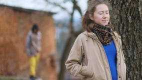 Menina grávida moreno consideravelmente jovem em vistas bege da reunião do revestimento com o desconhecido alto na capa e na calç vídeos de arquivo Menina grávida moreno consideravelmente jovem em vistas bege da reunião do revestimento com o desconhecido alto na capa e na calç vídeos de arquivo