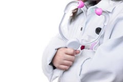 A menina guarda o estetoscópio do brinquedo, fingindo ser um doutor; em imagem de stock A menina guarda o estetoscópio do brinquedo, fingindo ser um doutor; em imagem de stock