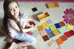 A menina joga o jogo tradicional do tangram imagem de stock A menina joga o jogo tradicional do tangram imagem de stock