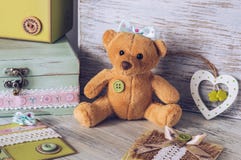 Menina macia do urso do brinquedo com uma curva Brinque em uma tabela de madeira com uma caixa e um coração foto de stock Menina macia do urso do brinquedo com uma curva Brinque em uma tabela de madeira com uma caixa e um coração foto de stock