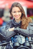 Menina no equipamento do moto com uma motocicleta imagens de stock royalty free Menina no equipamento do moto com uma motocicleta imagens de stock royalty free