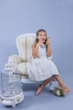 Menina no vestido que fala com o telefone velho com cara surpreendida foto de stock Menina no vestido que fala com o telefone velho com cara surpreendida foto de stock