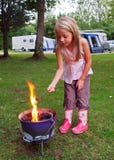 Menina que brinda marshmallows no incêndio do acampamento imagens de stock Menina que brinda marshmallows no incêndio do acampamento imagens de stock