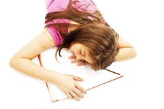 Menina que dorme com sua cabeça em um livro aberto fotos de stock Menina que dorme com sua cabeça em um livro aberto fotos de stock
