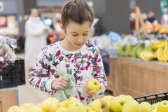 Menina que escolhe maçãs maduras em uma despensa ou em um supermercado fotos de stock Menina que escolhe maçãs maduras em uma despensa ou em um supermercado fotos de stock