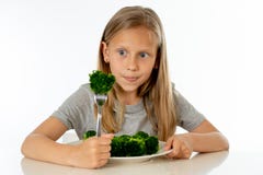 Menina saudável feliz de Yong que come seus vegetais dos brócolis no conceito saudável comer foto de stock Menina saudável feliz de Yong que come seus vegetais dos brócolis no conceito saudável comer foto de stock