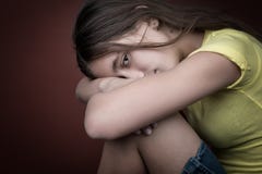 Menina triste com sua cabeça que descansa em seus pés imagem de stock royalty free Menina triste com sua cabeça que descansa em seus pés imagem de stock royalty free