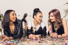 meninas multi-étnicos alegres novas que encontram-se no assoalho com vidros imagens de stock meninas multi-étnicos alegres novas que encontram-se no assoalho com vidros imagens de stock