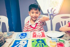 Menino asiático que sorri e que mostra as mãos na pintura estilo do pop art fotos de stock Menino asiático que sorri e que mostra as mãos na pintura estilo do pop art fotos de stock