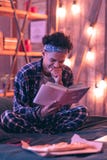 Menino brincalhão que encontra um humor no livro grosso sobre a natureza e a saúde, e esquecendo mesmo sobre a pizza fotos de stock Menino brincalhão que encontra um humor no livro grosso sobre a natureza e a saúde, e esquecendo mesmo sobre a pizza fotos de stock