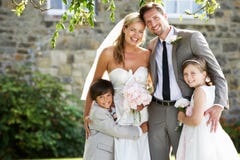 Menino da página de With Bridesmaid And dos noivos no casamento fotos de stock Menino da página de With Bridesmaid And dos noivos no casamento fotos de stock
