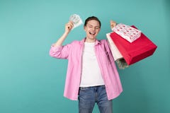 Menino de sorriso feliz na camisa cor-de-rosa com partes traseiras do dinheiro e da compra nas mãos foto de stock Menino de sorriso feliz na camisa cor-de-rosa com partes traseiras do dinheiro e da compra nas mãos foto de stock