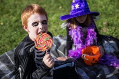 Menino e menina que vestem o traje do Dia das Bruxas com doces esqueleto bruxa foto de stock Menino e menina que vestem o traje do Dia das Bruxas com doces esqueleto bruxa foto de stock