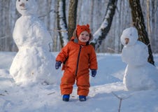 Menino europeu e o boneco de neve em uma floresta nevado fotografia de stock royalty free Menino europeu e o boneco de neve em uma floresta nevado fotografia de stock royalty free