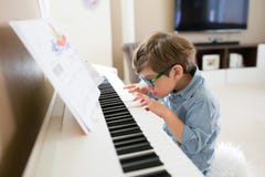 Menino focalizado da criança que joga o piano fotos de stock royalty free Menino focalizado da criança que joga o piano fotos de stock royalty free