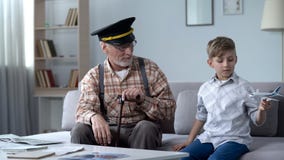 Menino que joga com avião do brinquedo, piloto anterior do vovô orgulhoso do neto, trabalho ideal imagens de stock royalty free Menino que joga com avião do brinquedo, piloto anterior do vovô orgulhoso do neto, trabalho ideal imagens de stock royalty free