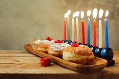 Menorah e filhóses para o Hanukkah judaico do feriado na tabela de madeira imagem de stock Menorah e filhóses para o Hanukkah judaico do feriado na tabela de madeira imagem de stock