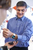 Mens die Betaling Zonder contact App op Slim Horloge in Opslag gebruiken stock foto Mens die Betaling Zonder contact App op Slim Horloge in Opslag gebruiken stock foto