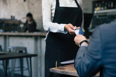 Mens die creditcard geven aan kelner in koffie royalty-vrije stock fotografie Mens die creditcard geven aan kelner in koffie royalty-vrije stock fotografie