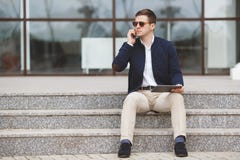 Mens die op de telefoonzitting spreken op de treden royalty-vrije stock afbeelding Mens die op de telefoonzitting spreken op de treden royalty-vrije stock afbeelding