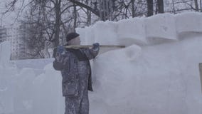 Mens die Sneeuw schept Maak beeldhouwwerk van sneeuw wordt gemaakt die Het sneeuwbeeldhouwwerk, blokkeert Opgestapeld Wachten voo stock video Mens die Sneeuw schept Maak beeldhouwwerk van sneeuw wordt gemaakt die Het sneeuwbeeldhouwwerk, blokkeert Opgestapeld Wachten voo stock video