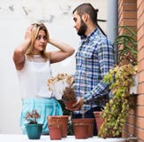 Mens die verontschuldigingen voor het water geven van meisjes geen bloemen maken Stock Afbeelding Mens die verontschuldigingen voor het water geven van meisjes geen bloemen maken Stock Afbeelding