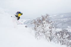 Mens in gele sprongen van een kroonlijst dichtbij de top van een kleine piek in backcountry van Hokkaido, Japan stock foto's Mens in gele sprongen van een kroonlijst dichtbij de top van een kleine piek in backcountry van Hokkaido, Japan stock foto's