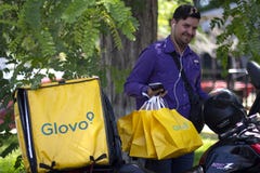 Mens met Glovo-zakken die bij de dienst van de voedsellevering werken royalty-vrije stock fotografie Mens met Glovo-zakken die bij de dienst van de voedsellevering werken royalty-vrije stock fotografie