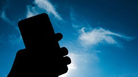 Menselijke hand met het silhouet van smartphoneschaduwen op heldere hemel, technologie-concept royalty-vrije stock afbeelding Menselijke hand met het silhouet van smartphoneschaduwen op heldere hemel, technologie-concept royalty-vrije stock afbeelding