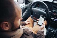 Mensenbestuurder die mobiele telefoon met gps toepassing in zijn auto, moderne navigatietechnologie voor reis houden en concept d stock fotografie Mensenbestuurder die mobiele telefoon met gps toepassing in zijn auto, moderne navigatietechnologie voor reis houden en concept d stock fotografie