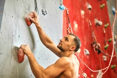 Mensenklimmer op kunstmatige het beklimmen muur in het bouldering van gymnastiek stock foto Mensenklimmer op kunstmatige het beklimmen muur in het bouldering van gymnastiek stock foto