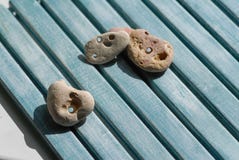 Mensonge de trois petit seastones sur un fond bleu en bois photo stock Mensonge de trois petit seastones sur un fond bleu en bois photo stock