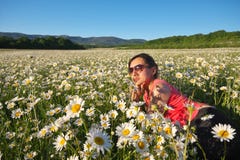 Mentira de la muchacha en campo de flor de la primavera de la rueda de margarita foto de archivo libre de regalías Mentira de la muchacha en campo de flor de la primavera de la rueda de margarita foto de archivo libre de regalías