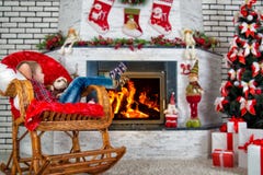 Merry Christmas and Happy Holidays!Child boy sitting near decorated Christmas tree and fireplace in comfortable rocking chair. royalty free stock photo Merry Christmas and Happy Holidays!Child boy sitting near decorated Christmas tree and fireplace in comfortable rocking chair. royalty free stock photo