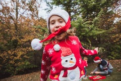 Merry Christmas and Happy Holidays. Pretty girl in red sweater and Christmas hat has fun, and her family decorates a Christmas tre royalty free stock photos Merry Christmas and Happy Holidays. Pretty girl in red sweater and Christmas hat has fun, and her family decorates a Christmas tre royalty free stock photos