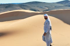 Merzouga, Morocco - December 05, 2018: joven berebere caminando por el desierto mirando a cámara royalty free stock image Merzouga, Morocco - December 05, 2018: joven berebere caminando por el desierto mirando a cámara royalty free stock image