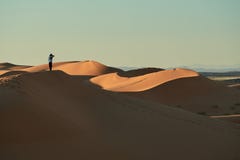 Merzouga, Марокко - 5-ое декабря 2018: человек в середине пустыни, поверх дюны стоковые изображения rf Merzouga, Марокко - 5-ое декабря 2018: человек в середине пустыни, поверх дюны стоковые изображения rf