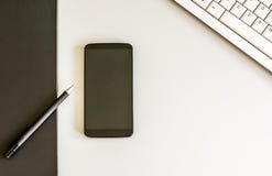 Mesa com o teclado do smartphone, da pena e de computador visto de cima de foto de stock Mesa com o teclado do smartphone, da pena e de computador visto de cima de foto de stock