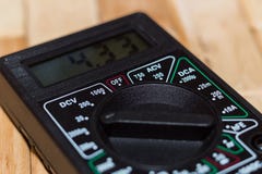 Messendes Vielfachmessgerät Digital auf Bretterboden Es zeigt 4 33V oder völlig aufgeladene Batterie Schließt Voltmeter, ampermet lizenzfreies stockfoto Messendes Vielfachmessgerät Digital auf Bretterboden Es zeigt 4 33V oder völlig aufgeladene Batterie Schließt Voltmeter, ampermet lizenzfreies stockfoto