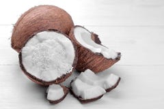 Metades do coco com aparas do coco e partes pequenas de coco em um fundo branco imagem de stock royalty free Metades do coco com aparas do coco e partes pequenas de coco em um fundo branco imagem de stock royalty free